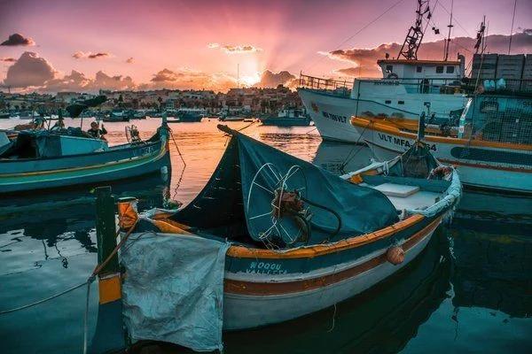Observe the sunset in a fishing community.